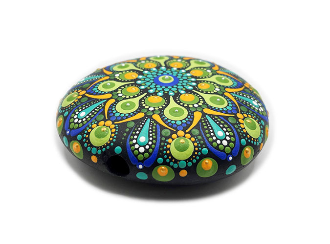 A green and blue dot mandala stone